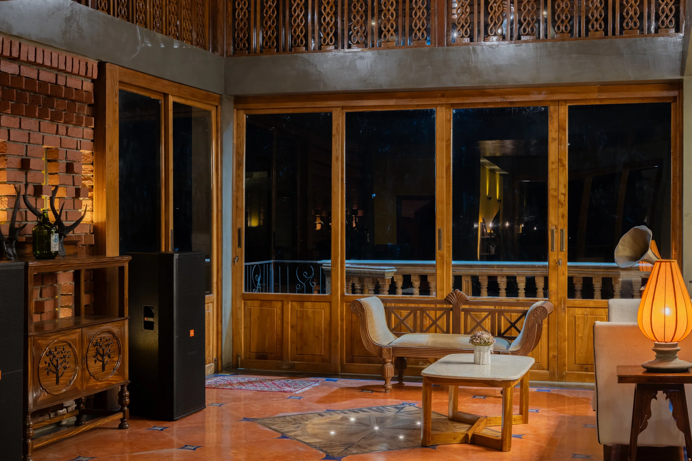 Wide evening lounge with handcrafted seating, timber windows and warm lighting at RedKing
