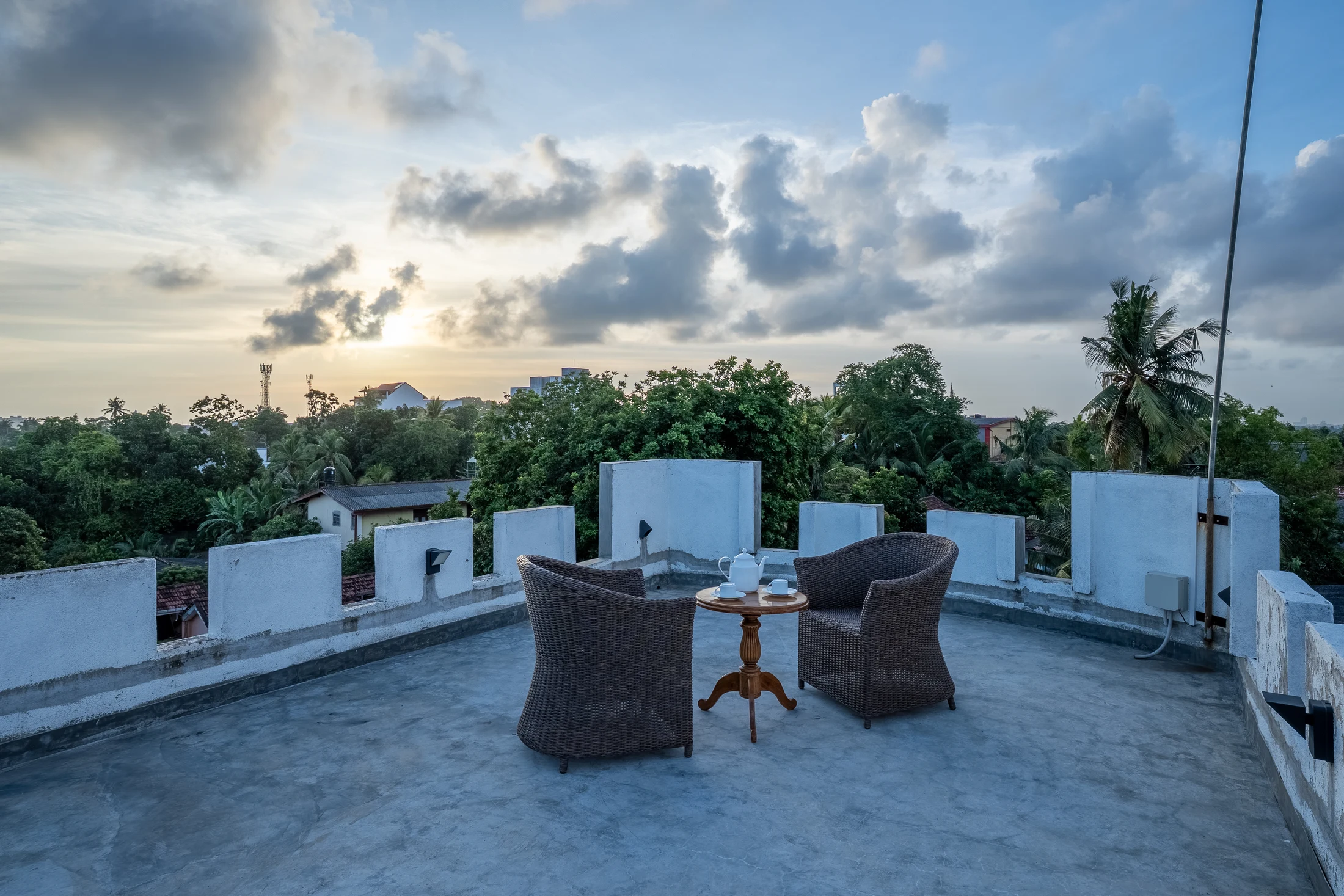 Full rooftop terrace with seating, open floor space and sunset skyline