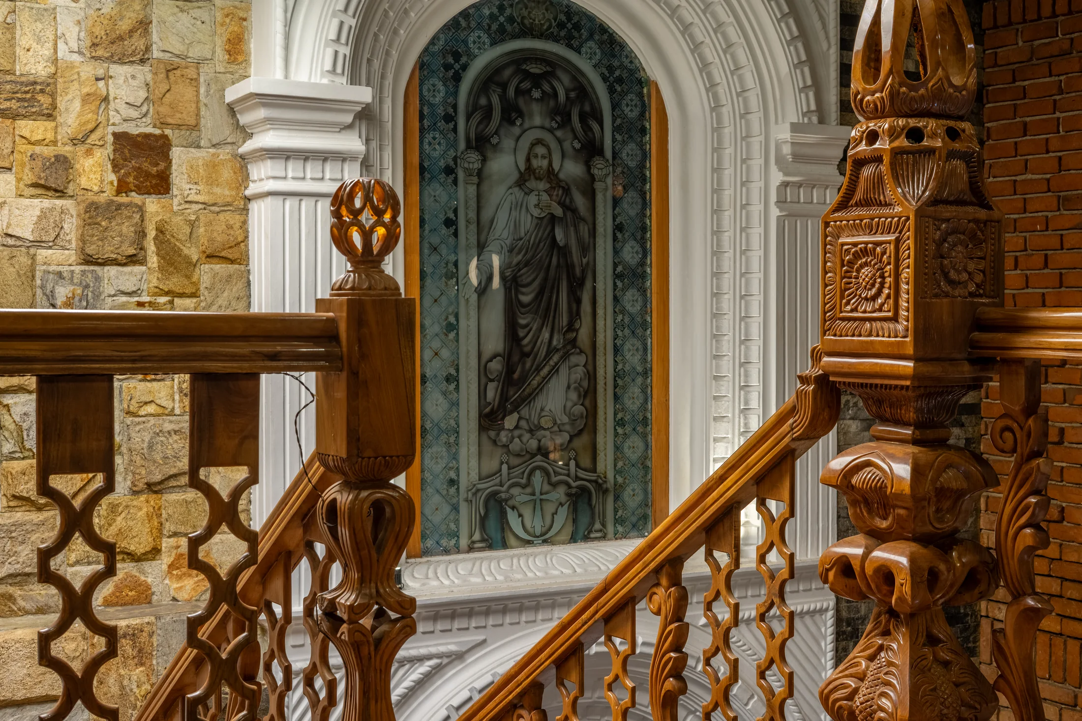 Carved timber balustrade and religious alcove inside the residence